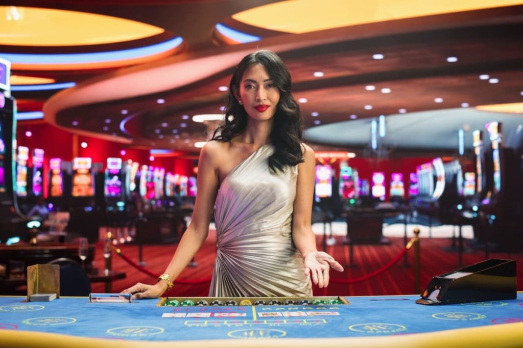 crupier in fata unei mese de blackjack intr-un studio de casino online live