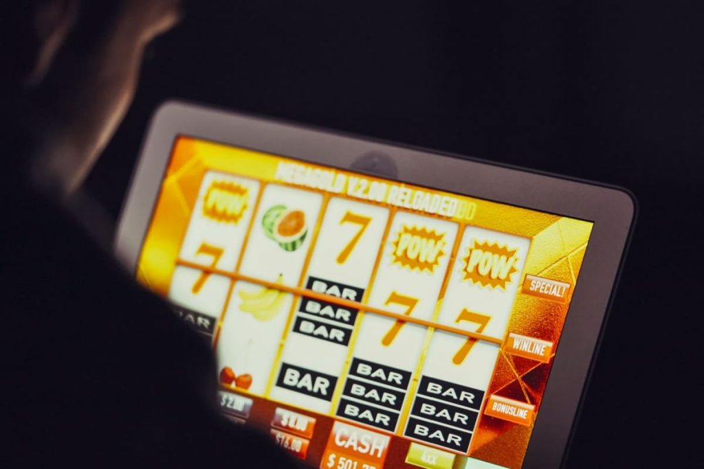 barbat jucand sloturi online pe o tableta